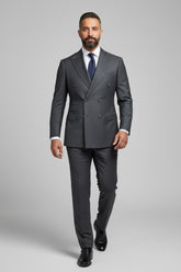Man in charcoal pinstripe double-breasted suit with tailored fit and tie.